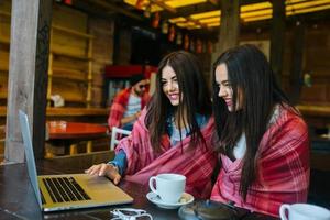 twee meisjes kijken naar iets in de laptop foto