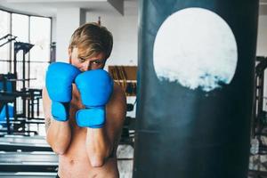 bokser met ponsen zak in Sportschool foto