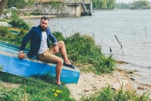 Amerikaans gebaard Mens looks Aan de rivier- bank foto