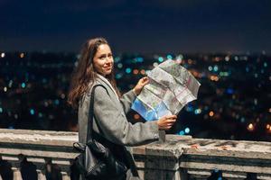 meisje met een kaart Aan de achtergrond van de nacht stad foto