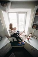 moeder en haar dochter meisje Speel in kinderen kamer foto