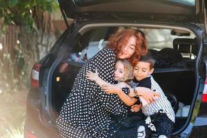 gelukkig vrouw zittend met haar kinderen in de auto foto