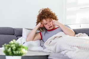 van streek depressief jong vrouw aan het liegen Aan bankstel gevoel sterk hoofdpijn migraine, verdrietig moe slaperig tiener uitgeput meisje resting proberen naar slaap na nerveus spanning en spanning, slaperigheid concept foto