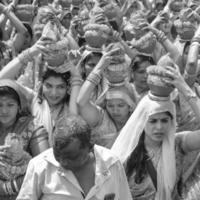 Delhi, Indië april 03 2022 - Dames met kalash Aan hoofd gedurende jagannath tempel mangal kalash jatra, Indisch Hindoe toegewijden dragen aarden potten met heilig water met kokosnoot Aan top-zwart en wit foto