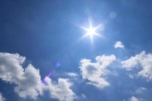 prachtig zicht bij zonnestralen met wat lensflares en wolken in een blauwe lucht foto