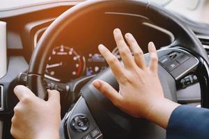 man duwt hoorn tijdens het rijden zittend van een stuurwiel persauto, toeterend geluid om andere mensen in verkeersconcept te waarschuwen. foto