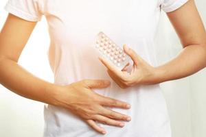 vrouw handen openen anticonceptiepillen in de hand. anticonceptiepil eten. anticonceptie vermindert het concept van bevalling en zwangerschap. foto