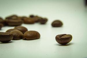 de manier koffie bonen leggen Aan een wit achtergrond, elegant en heerlijk koffie bonen en de aroma van ochtend- koffie. foto