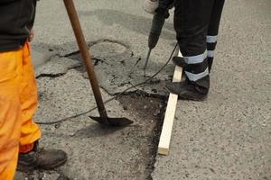 arbeiders reparatie de asfalt. vervanging van de weg oppervlak. foto