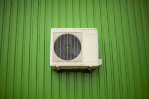 lucht conditioning Aan de groen muur van de gebouw. koeling uitrusting Bij werk. foto