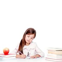 gelukkig en schattig tiener school- meisje schrijft in een boek of notitieboekje foto