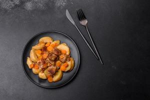 rundvlees vlees en groenten stoofpot Aan een zwart bord met geroosterd aardappelen foto