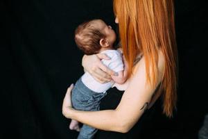 jong moeder vrouw Holding haar kind baby foto