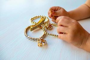 kinderen handen Speel met goud sieraden en bijouterie, Aan wit achtergrond. concept van vrouwen happines foto