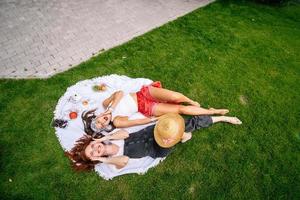 top visie, twee jong Dames aan het liegen in de park foto