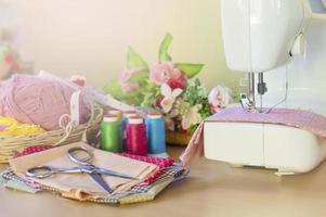 dichtbij omhoog van naaien machine werken met roze kleding stof, naaien accessoires foto