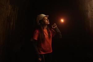 vrouw graver met zaklamp onderzoekt de tunnel foto
