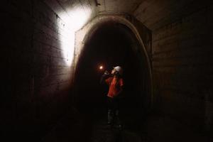 vrouw graver met zaklamp onderzoekt de tunnel foto