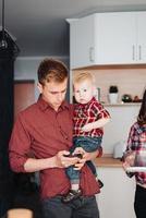 vader en weinig zoon in de keuken door de koelkast foto