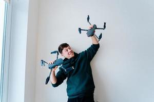 vent houdt twee quadrocopters tegen een muur foto