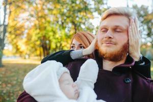 jong familie en pasgeboren zoon in herfst park foto