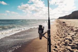 meerdere visvangst staven in een rij Aan de strand foto