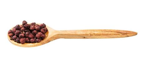 houten lepel met droog schisandra fruit geïsoleerd foto