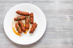 schapenvlees seekh kabab Aan wit bord Aan tafel foto