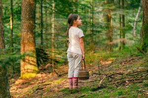 meisje met een mand kwijt. staat in de Woud alleen en looks Bij de bomen foto