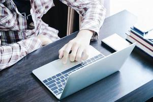 mannetje werken met laptop computer Aan de tafel foto