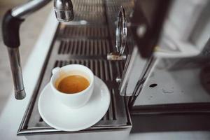 detailopname visie van glas kop met cappuccino en koffie machine foto