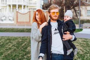 gelukkig mam vader en zoon knuffelen in de park foto