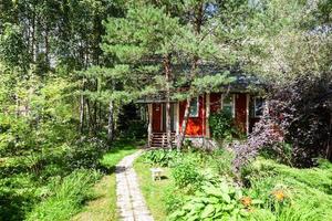 hout land huis in overwoekerd sier- tuin foto