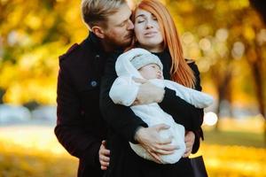 jong familie en pasgeboren zoon in herfst park foto