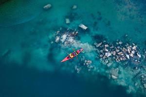 twee atletisch Mens drijft Aan een rood boot in rivier- foto