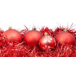 vier rood Kerstmis kerstballen en klatergoud geïsoleerd foto