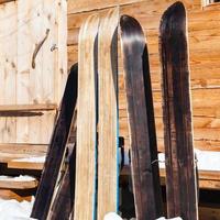 breed Woud skis in de buurt deur van houten huisje foto