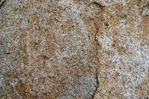 ruwe grijze granieten rots textuur achtergrond. fragment van natuurstenen muur foto