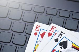 poker papier kaarten Aan blanco laptop toetsenbord, zacht en selectief focus, concept voor spelen kaarten online met andere mensen Bij huis en recreatief werkzaamheid. foto