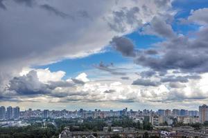 onweerswolken vullen de blauw lucht bovenstaand de stad. foto