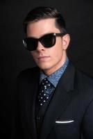 stijlvolle jonge zakenman met zwarte retro zonnebril.