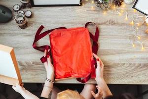 vrouw omhulsel Cadeau in papier met rood lintje. foto