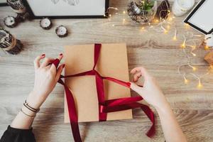 vrouw omhulsel Cadeau in papier met rood lintje. foto