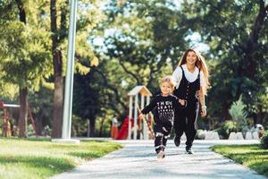 moeder en weinig zoon zijn wandelen in de park foto