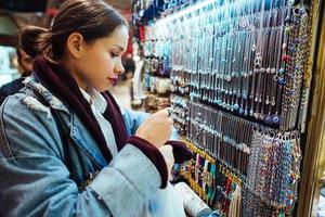 jong meisje toerist wandelen in de souvenir markt foto