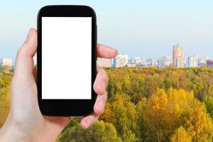smartphone met besnoeiing uit scherm stad herfst Woud foto