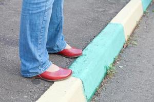 poten in rood schoenen Aan stedelijk trottoir in herfst dag foto