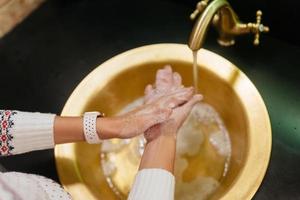 dichtbij omhoog foto van vrouw wast haar handen met zeep en water.