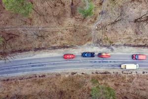 meerdere auto's met kajaks Aan dak rek het rijden Aan de weg tussen bomen foto