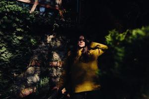 vrouw poseren in de schaduw van van bladeren foto